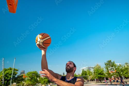 Canvas Print Male sportsman playing basketball throwing the ball at playground