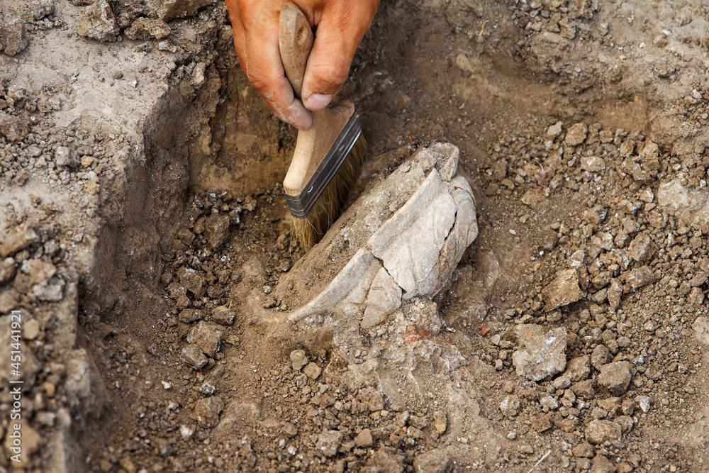 Archaeological excavations, archaeologists work, dig up an ancient clay artifact with special tools Archaeological excavations, archaeologists work, dig up an ancient clay artifact with special tools