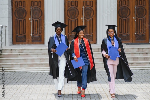 portrait of multiracial graduates holding diploma