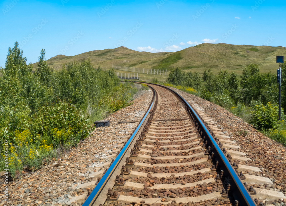 Railway in the steppe. Outskirts of Ust-Kamenogorsk (Kazakhstan). Central Asia. Bright summer landscape