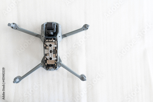 Top view opened drone with circuit board on white table with copy space.