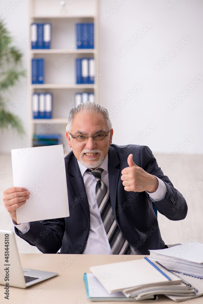 Old male employee working in the office Old male employee working in the office