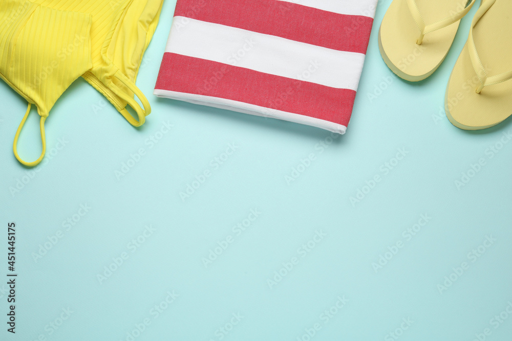 Fototapeta premium Flat lay composition with different beach objects on light blue background, space for text
