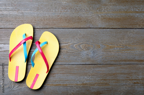 Stylish flip flops on wooden background, flat lay. Space for text