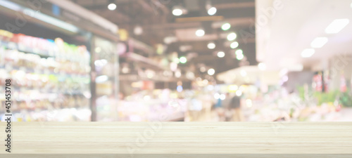 Wood table top with supermarket grocery store blurred background with bokeh light for product display