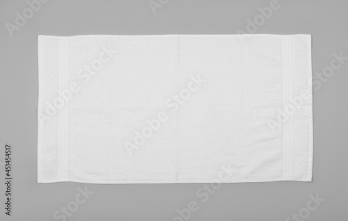White beach towel on light grey background, top view