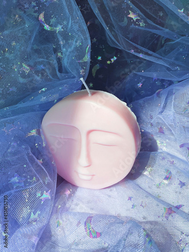 Картината върху платно pink candle made of soy wax and the form of a full moon with a face