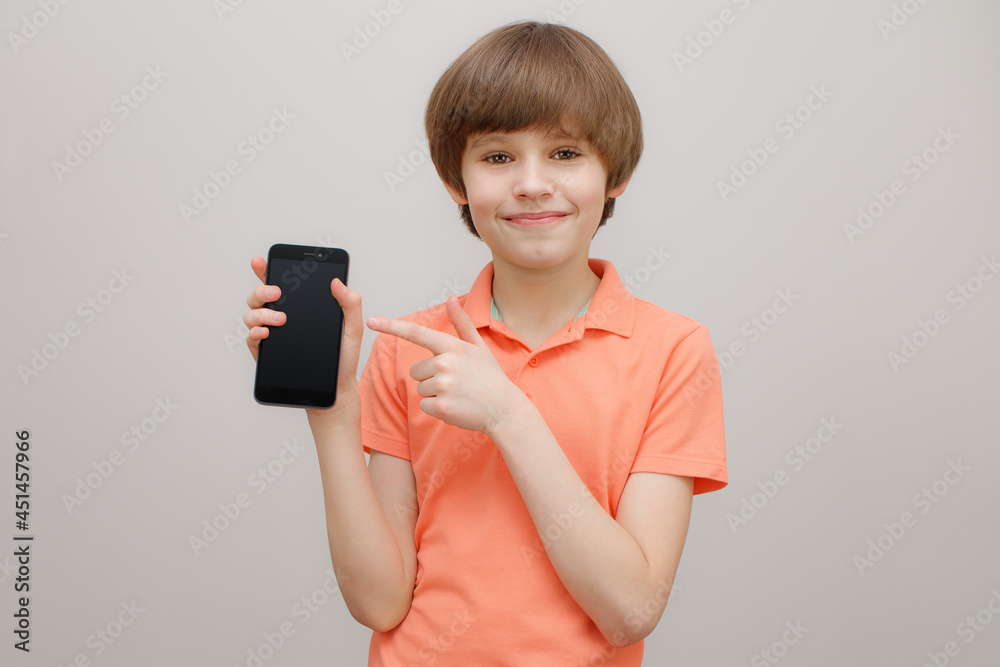 Smiling boy 9-10 year old showing something on smartphone screen Smiling boy 9-10 year old showing something on smartphone screen