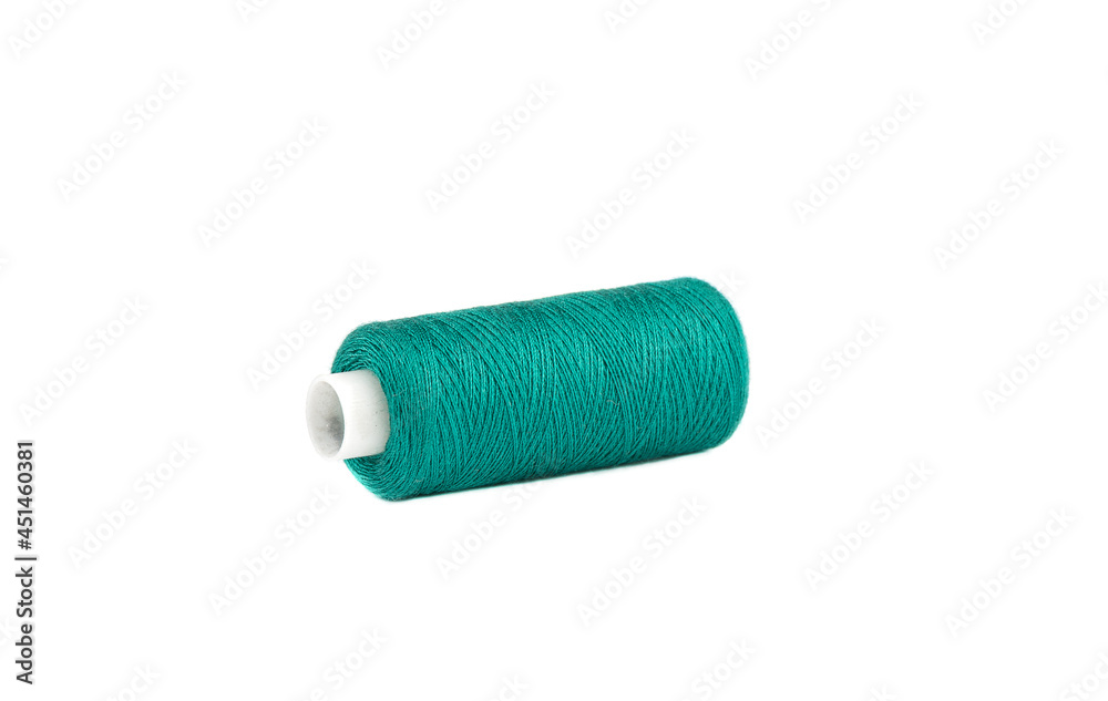 Spool of green thread lies on a white background. Spool of green thread lies on a white background.