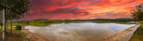 a stunning panoramic shot of the silky brown waters of the Chattahoochee river surrounded by green and autumn colored trees with powerful clouds at Sweetwater Creek State Park in Lithia Springs  GA photo