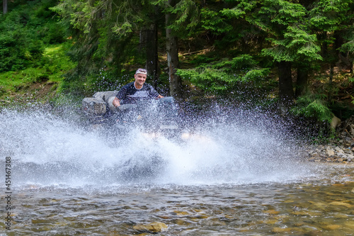 ATV racing on on mountain river  track at summer mountain