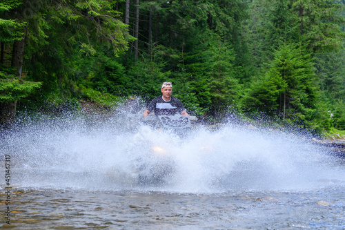 ATV racing on on mountain river track at summer mountain