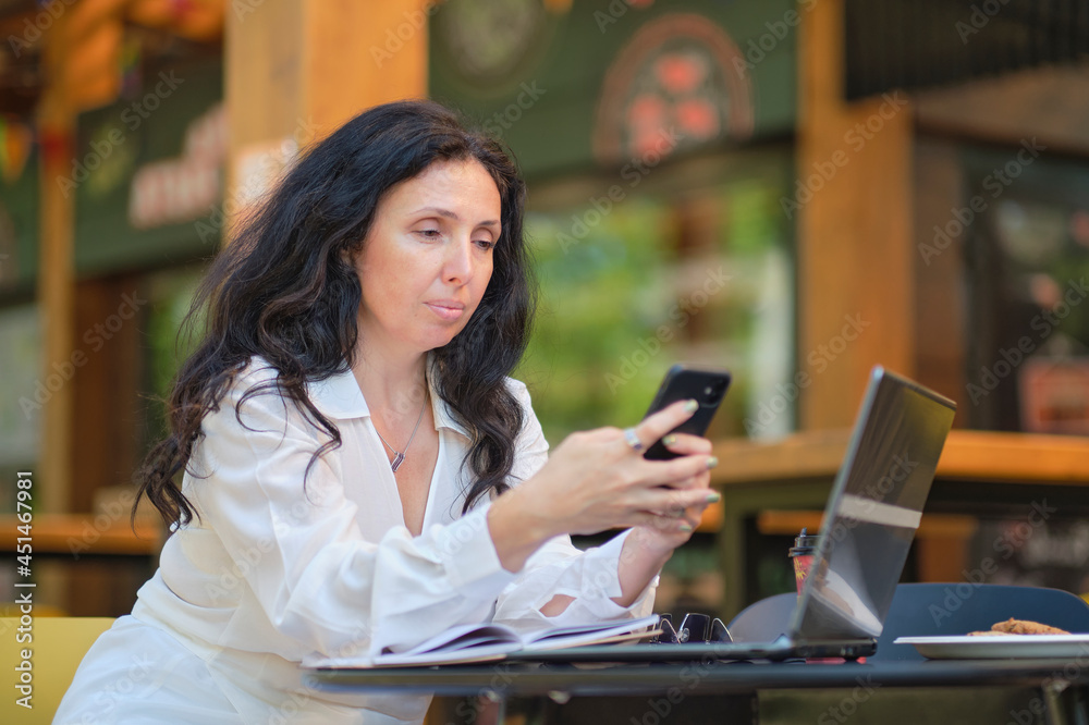 smiling mature businesswoman drinking coffee while working in cafe smiling mature businesswoman drinking coffee while working in cafe