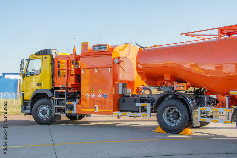 Truck releasing fuel oil stainless tanks in petrol station.