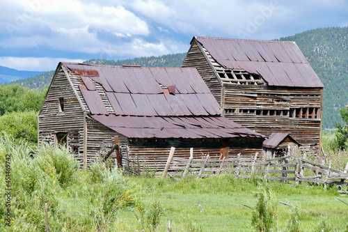 rustic, crumbling barn in a grassy field