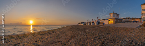 Langrune Sur Mer, France - 08 04 2020: Beach cabins on the beach at sunrise along the sea wall