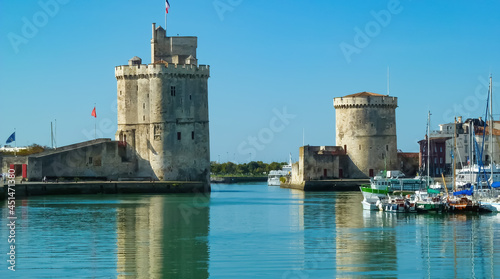 La Rochelle, France - September 9. 2016: View on harbor entrance with two medieval towers into breton town against blue summer sky