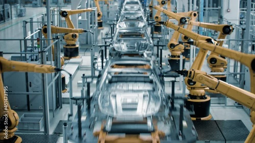 Car Factory 3D Concept: Automated Robot Arm Assembly Line Manufacturing High-Tech Green Energy Electric Vehicles. Automatic Construction, Welding Industrial Production Conveyor. Front View Time-Lapse
