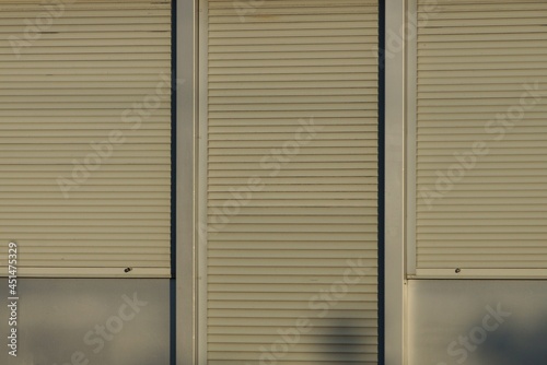door and windows closed with gray blinds on a plastic wall on the street © butus