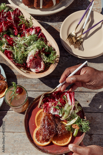 Person with a plate of food at an outdoor dinner party