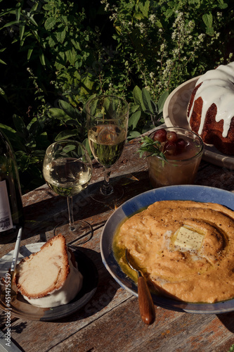 A bowl of grits on a table with wine and cocktails