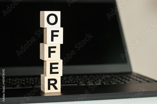 Letter block in word offer on wood background, wooden block on computer keyboard against black background