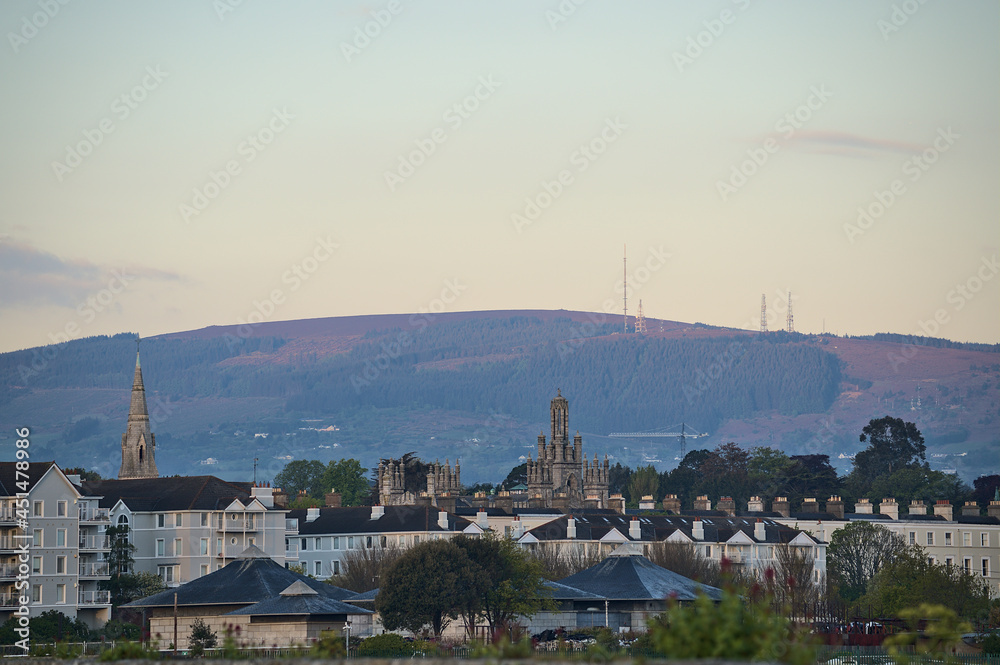 Beautiful morning view of roofs of houses, churches and castles, and Three Rock Mountain with cellular antennas seen from Dun Laoghaire harbor (West Pier), Dublin, Ireland. High resolution. Soft focus