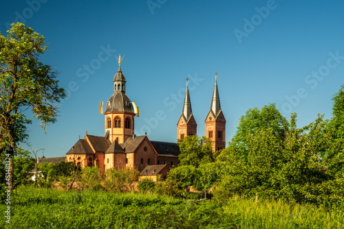 Ancient Einhard-Basilika with its two Romanesque Revival towers against the blue sky photo