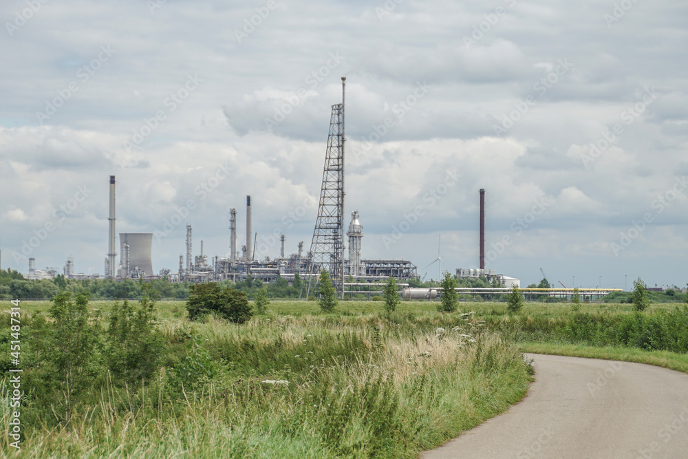 road in the countryside with industrial complex in background with power station