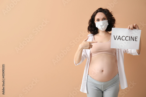 Young pregnant woman holdin...