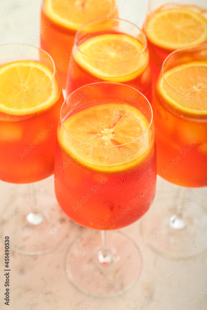 Glasses of Aperol spritz cocktail on light background