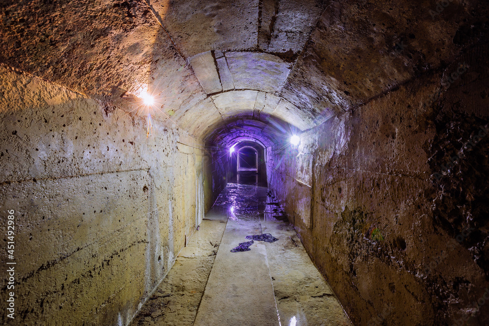 Old dark vaulted underground flooded drainage tunnel