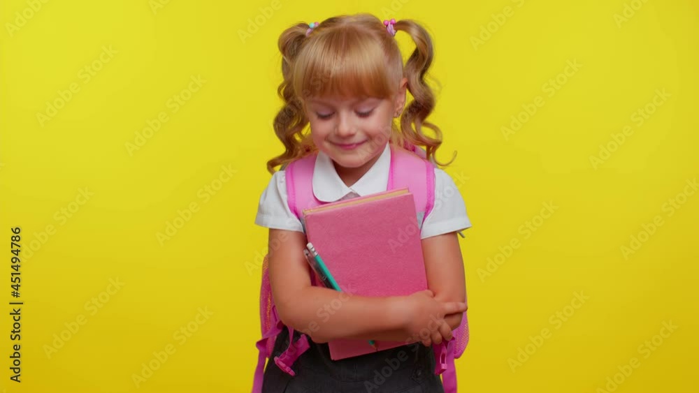 Little blonde teen child kid girl in school uniform listening music, smiling dancing to disco music rhythmically moving her hands, having fun on yellow studio background. Back to school. Childhood Little blonde teen child kid girl in school uniform listening music, smiling dancing to disco music rhythmically moving her hands, having fun on yellow studio background. Back to school. Childhood