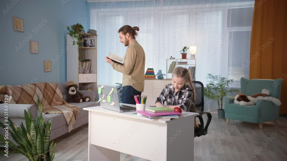 man helps girl do homework and reads dictation while teaching quarantined children man helps girl do homework and reads dictation while teaching quarantined children