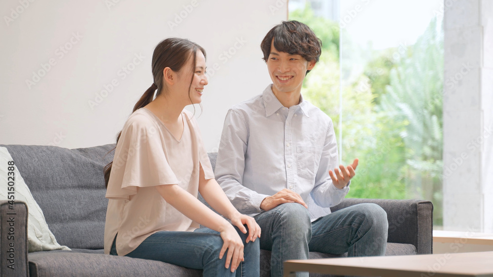 リビングで雑談をするカップル リビングで雑談をするカップル