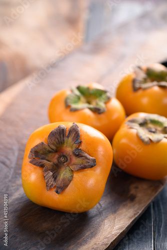 Ripe persimmon fruit on wooden background