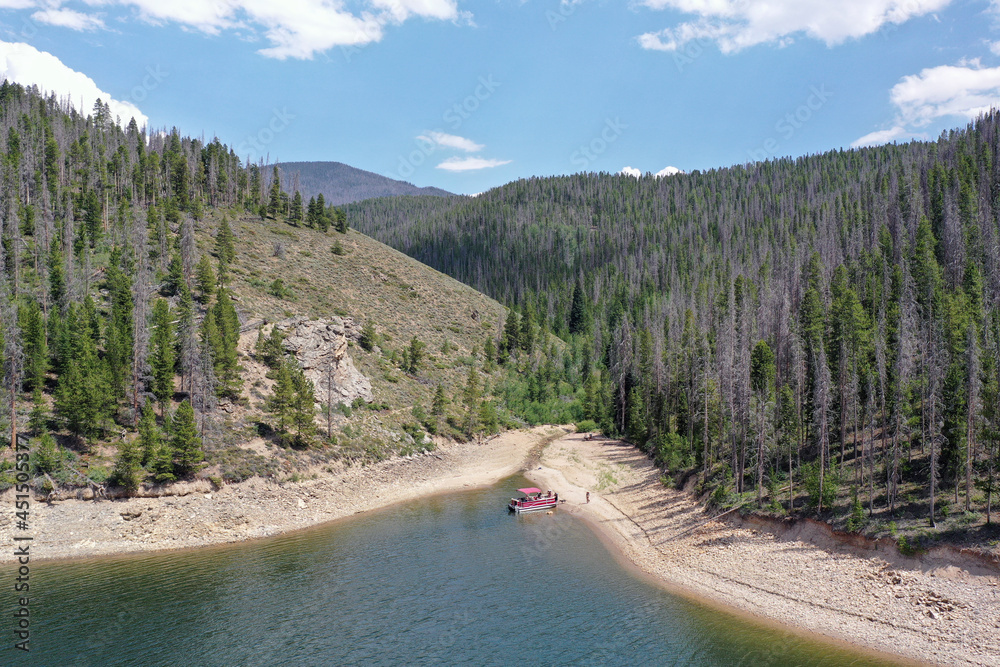Aerial view of family and friends enjoying afternoon boating on Lake Granby in Arapaho National Recreation Area, Colorado on sunny summer day.