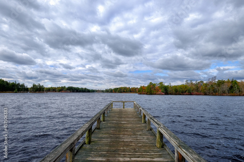 Wooden dock or pier stretching out into a lake on a dramatic cloudy day