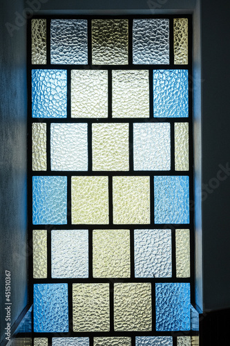 Vertical shot of a vitrage window in blue and yellow colors photo