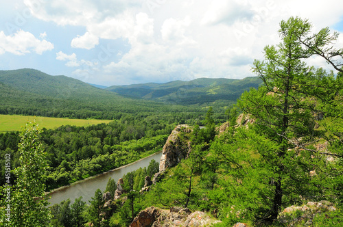 View of a picturesque valley surrounded by mountains and a flowing river.