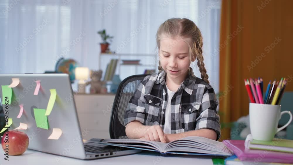 girl doing homework and reading a book with homework in room girl doing homework and reading a book with homework in room