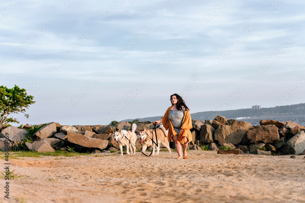 Ταπετσαρία one girl walking with two husky dogs at the beach