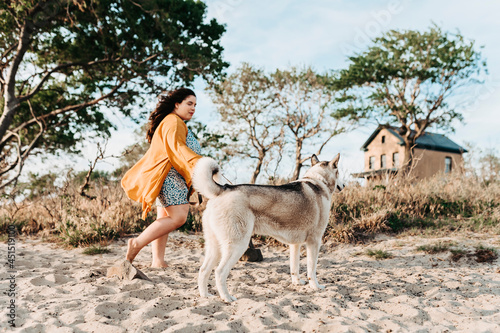 one girl walking with her husky dog at the beach © Alessandra Sawick