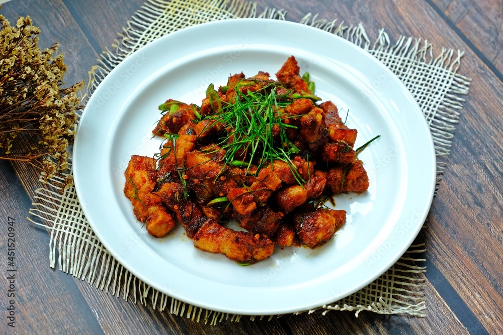 Stir fried crispy pork belly with ginger red curry paste, Authentic Thai food.