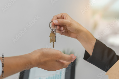 Hand of house, apartment agent or realtor holding key giving young man new landlord, tenant or renter. Banker approved signed signature purchase. Mortgage loan, real estate. Property of financial.
