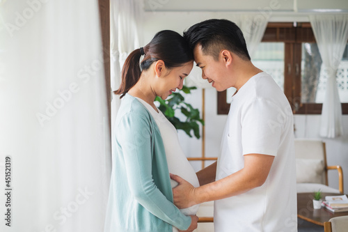 Asian couple pregnant woman with her husband feeling happy at home