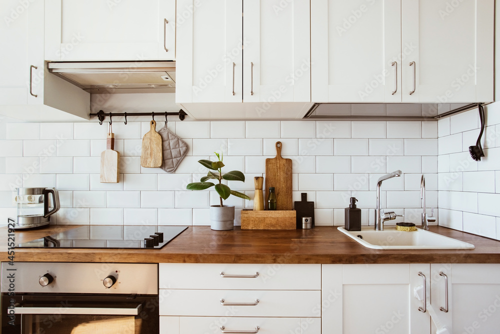 © KatrinaEra - Kitchen brass utensils, chef accessories. Hanging kitchen with white tiles wall and wood tabletop.Green plant on kitchen background © KatrinaEra - Kitchen brass utensils, chef accessories. Hanging kitchen with white tiles wall and wood tabletop.Green plant on kitchen background