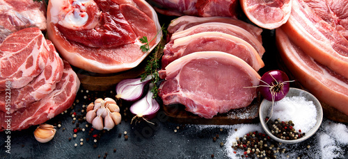 Different types of raw meat on black background