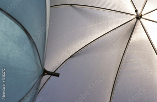 two white clothe umbrellas with black wire frames