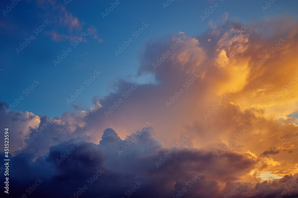 Obraz premium Clouds illuminated by the sun in the evening sky at sunset on a summer day